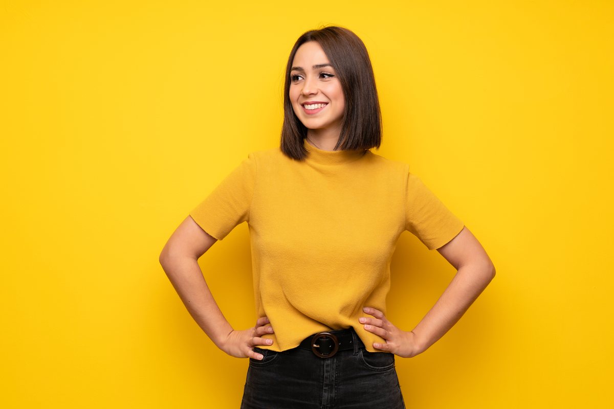 A subject photographed against a busy, distracting yellow wall.